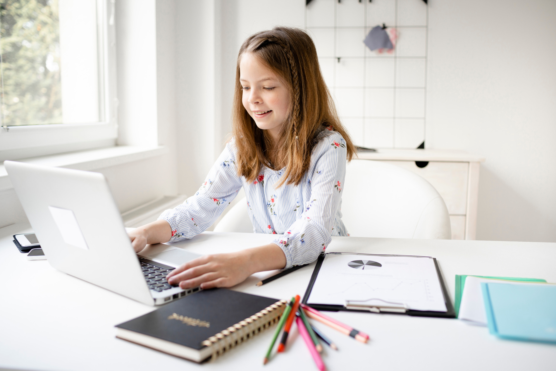 Schoolkid Using Laptop While Doing Schoolwork at Home